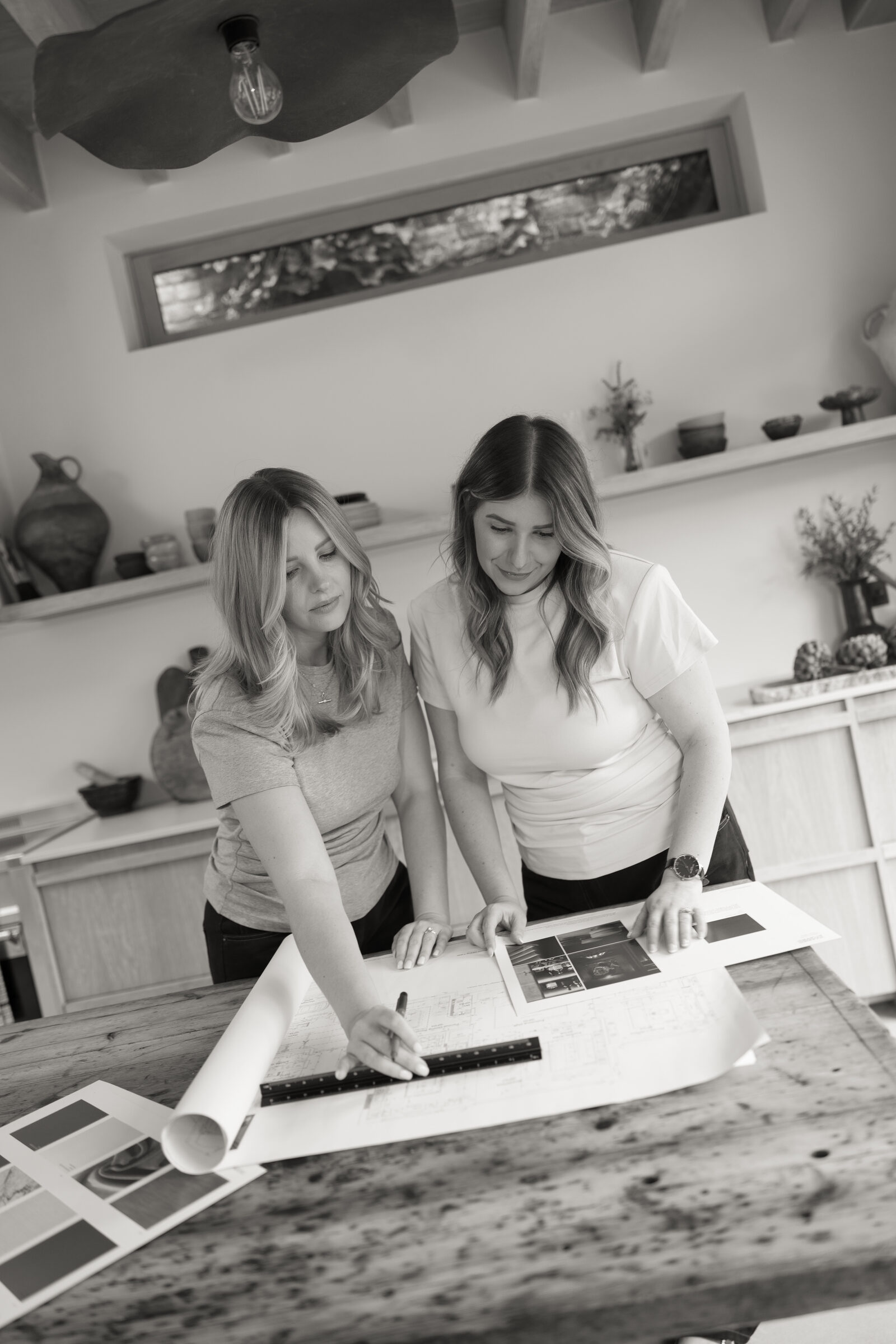 Poppy and Chantelle reviewing plans and material samples in the studio