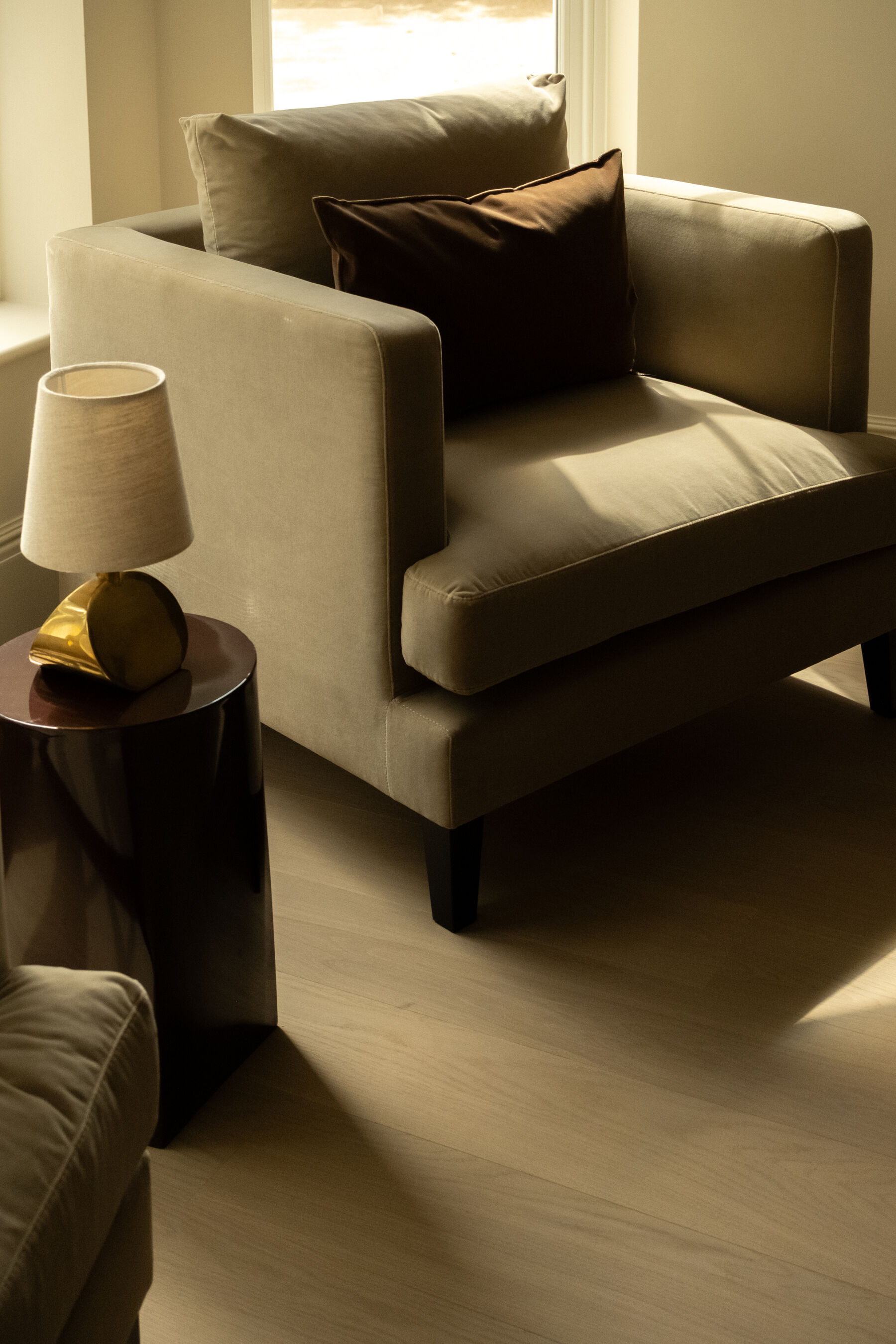 Velvet armchair with lacquered side table in morning light