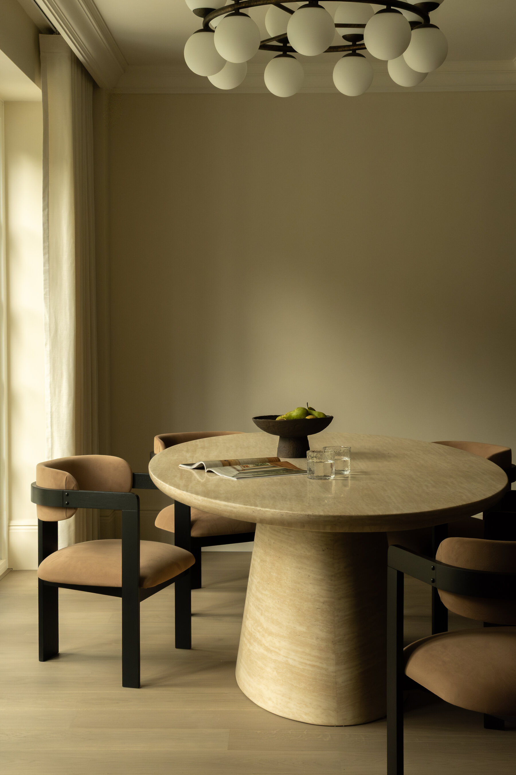 Round travertine dining table with sculptural chairs, Private Estate, London