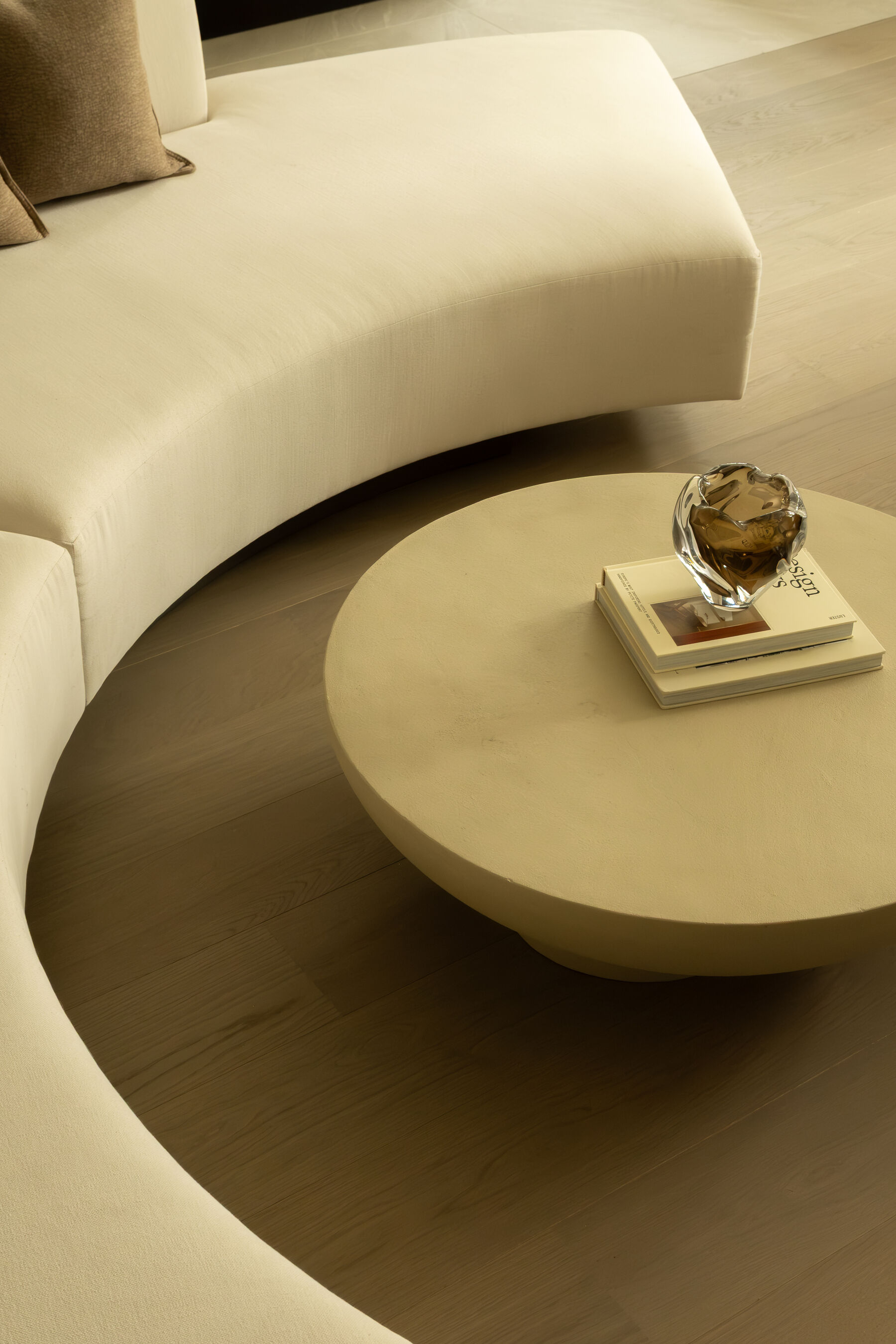 Curved sofa and plaster coffee table in a Younger & Turner interior