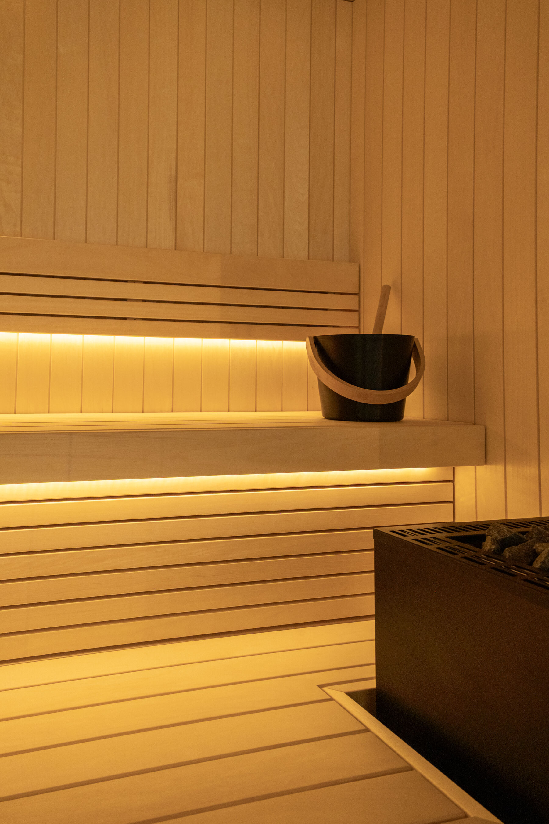 Sauna interior in pale timber with concealed lighting