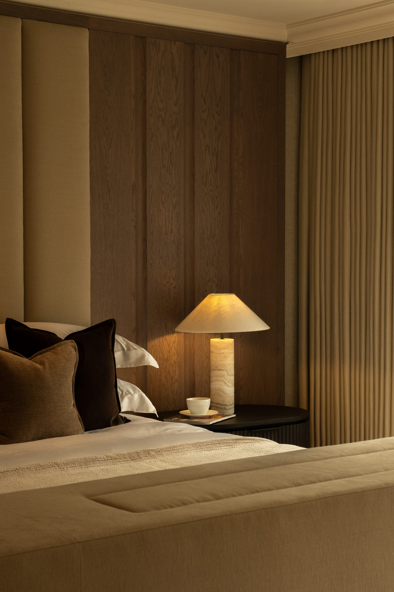 Bedside detail with fluted bedside table and marble lamp